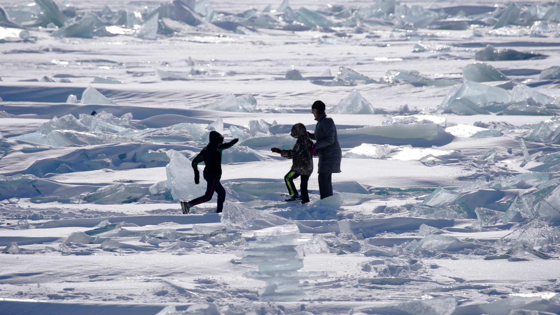 In this Friday, Feb. 22, 2019, photo, people are playing on the Ice on Lake Superior, starting to pack along the shore near Duluth, Minn., And attracting explorers and ice fishermen out onto the lake. Access to the mainland ice caves remain CLOSED. Ice continues to move quite a bit. Over the past few days, the open water has been seen from Meyers Beach as well as near Eagle Island. This ice is typically poor quality ice, which reacts poorly to movement due to weak bonding along the fractures. (Brian Peterson / Star Tribune via AP)